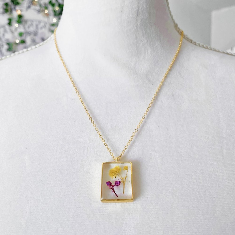 Yellow and purple floral botanical resin necklace in square gold bezel